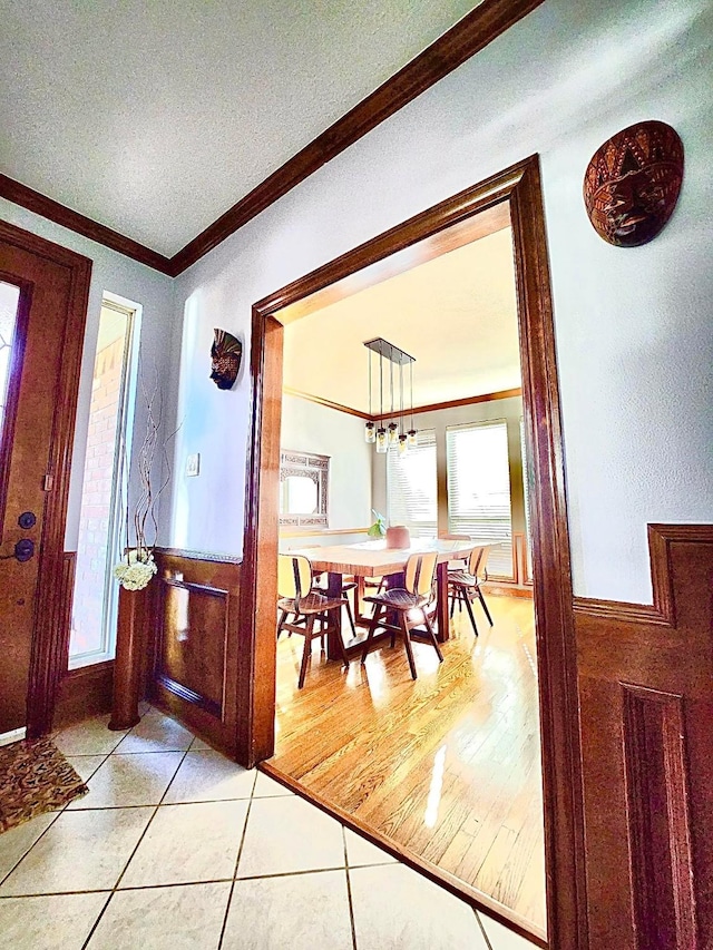 tiled dining space with ornamental molding and a textured ceiling