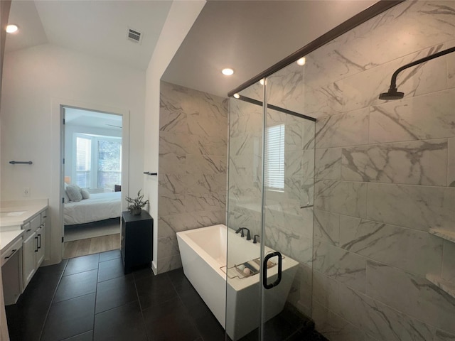 bathroom featuring vanity, vaulted ceiling, and shower with separate bathtub