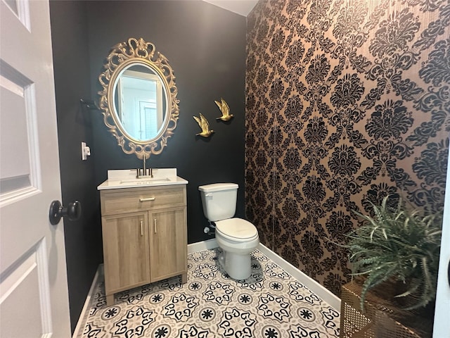 bathroom with toilet, tile patterned flooring, and vanity