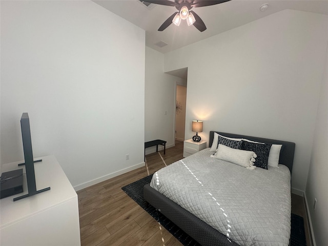 bedroom with ceiling fan, dark hardwood / wood-style floors, and lofted ceiling