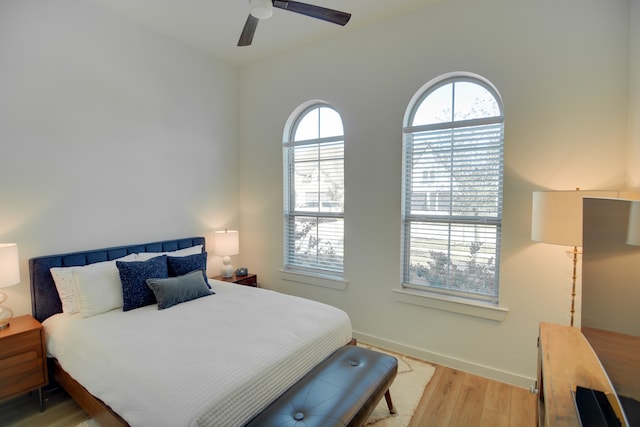 bedroom featuring ceiling fan, multiple windows, and light hardwood / wood-style flooring