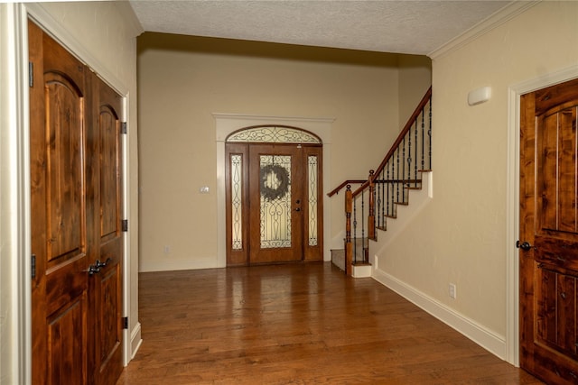 entryway featuring dark hardwood / wood-style flooring, crown molding, and a textured ceiling