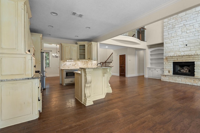235 Fm 3313, Crockett, TX 75835 - kitchen with cream cabinets, open floor plan, ornamental molding, a peninsula, and light stone countertops