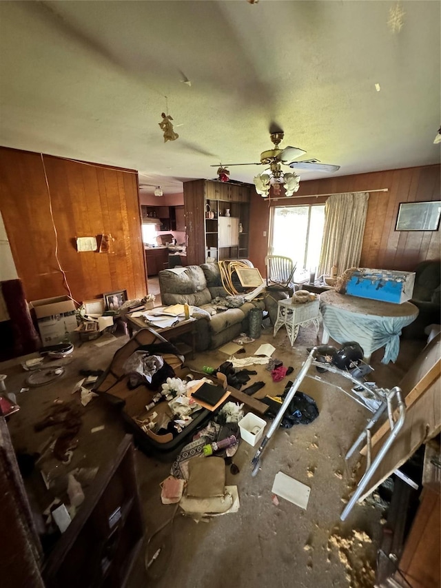 misc room featuring ceiling fan and wooden walls