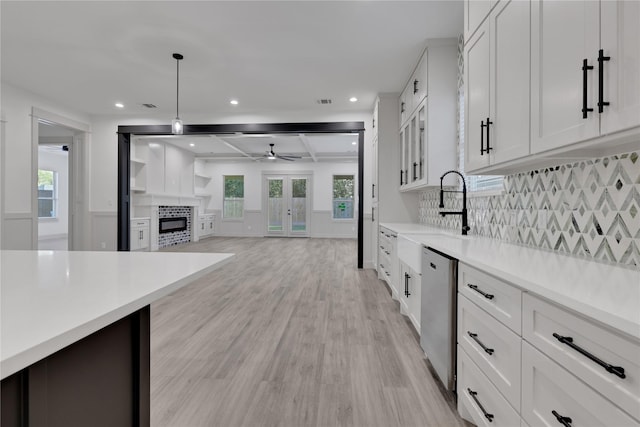 kitchen featuring ceiling fan, dishwasher, white cabinets, light hardwood / wood-style floors, and hanging light fixtures