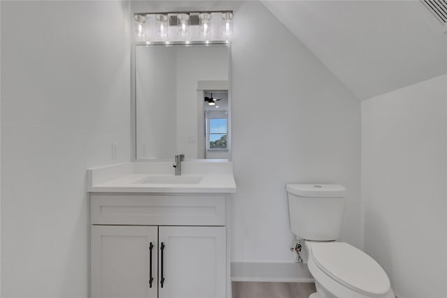 bathroom with hardwood / wood-style floors, vanity, lofted ceiling, ceiling fan, and toilet