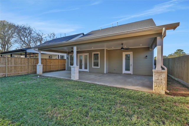 rear view of property with a lawn, a patio area, ceiling fan, and french doors