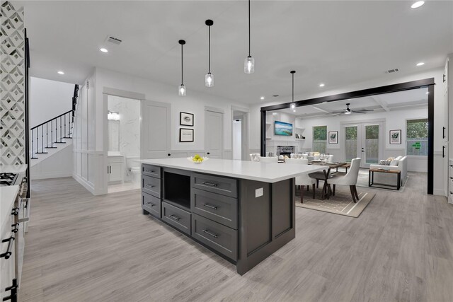 kitchen with a center island, decorative light fixtures, beam ceiling, and white cabinetry