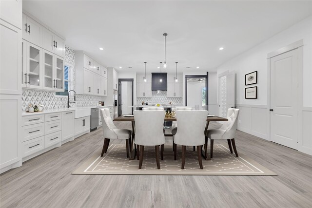 dining space with light hardwood / wood-style floors and sink