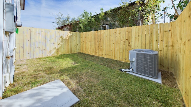 view of yard with central AC unit and a fenced backyard