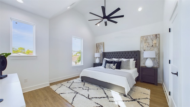 bedroom with ceiling fan, hardwood / wood-style floors, and high vaulted ceiling