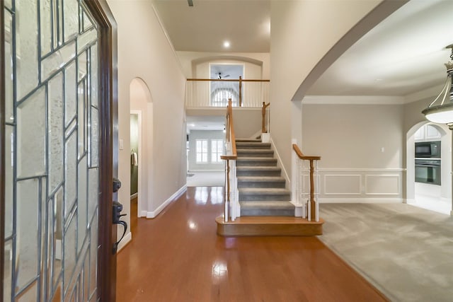 entryway with dark hardwood / wood-style floors and crown molding