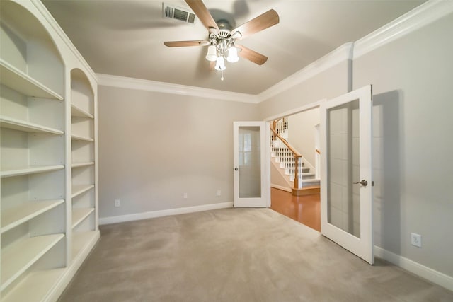 carpeted empty room featuring french doors, ceiling fan, and ornamental molding