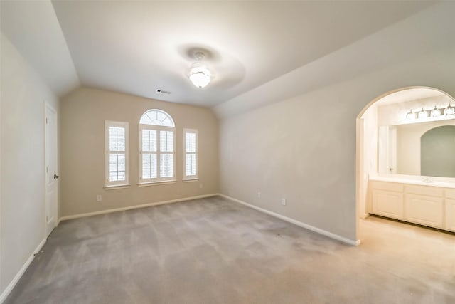 carpeted empty room with ceiling fan, sink, and lofted ceiling