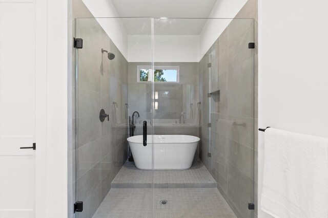 bathroom with a freestanding bath, tile patterned floors, and a shower stall