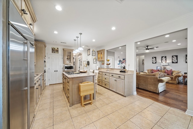 kitchen with a breakfast bar, crown molding, appliances with stainless steel finishes, a kitchen island, and pendant lighting