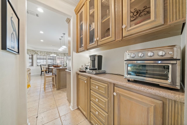 kitchen featuring pendant lighting and light stone countertops