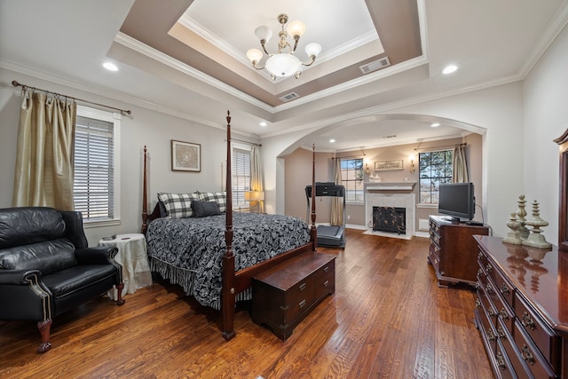 bedroom featuring crown molding, a tray ceiling, and dark hardwood / wood-style flooring