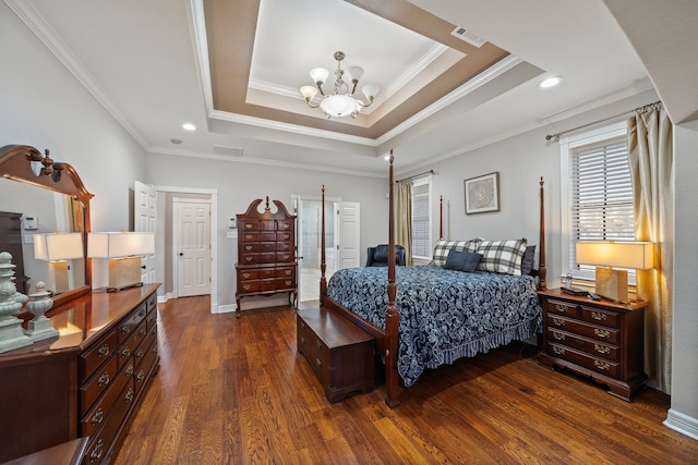 bedroom with an inviting chandelier, a tray ceiling, dark wood-type flooring, and ornamental molding