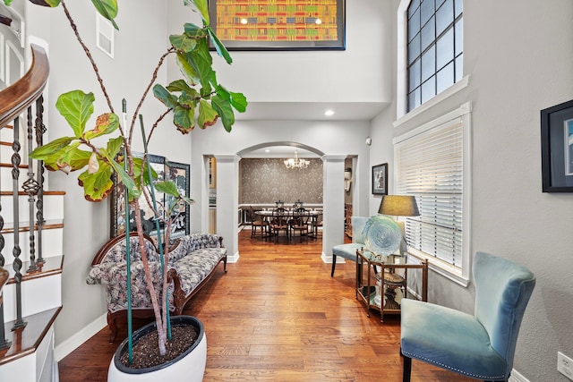 living area featuring hardwood / wood-style flooring, a wealth of natural light, and decorative columns