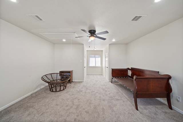 living area featuring light carpet and ceiling fan