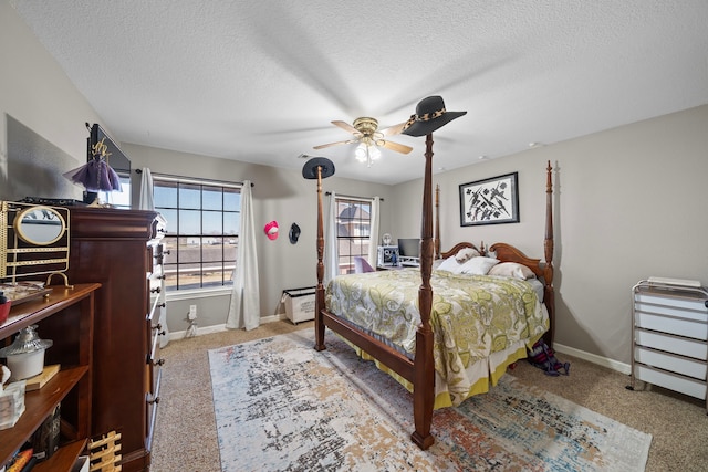 carpeted bedroom with multiple windows, a textured ceiling, and ceiling fan