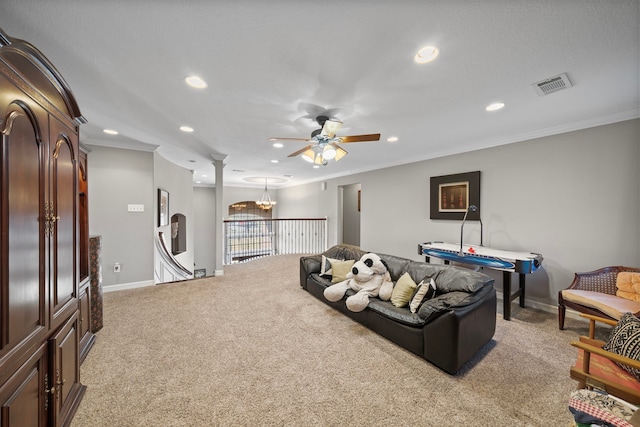 carpeted living room with ornamental molding and ceiling fan with notable chandelier