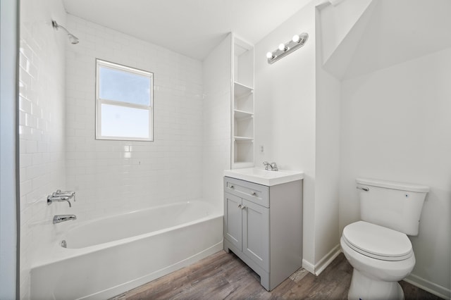 full bathroom featuring vanity, tiled shower / bath combo, wood-type flooring, and toilet