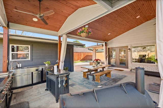 view of patio / terrace featuring ceiling fan, an outdoor kitchen, and french doors