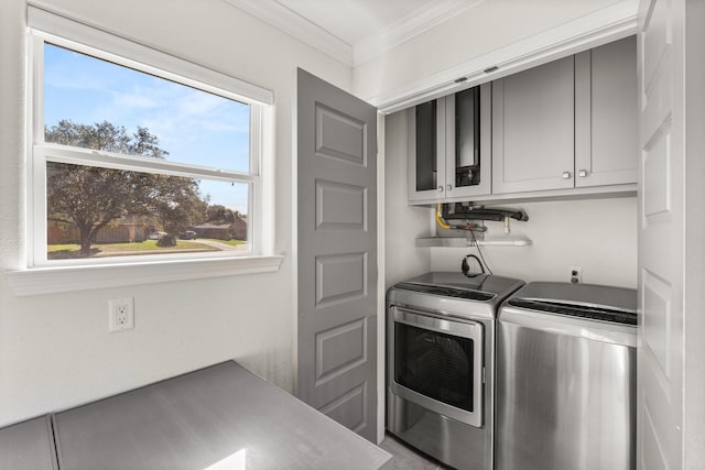 washroom with crown molding, washer and clothes dryer, and cabinets