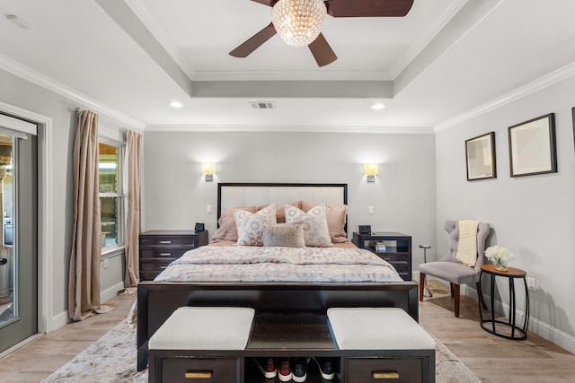 bedroom featuring a tray ceiling, crown molding, and ceiling fan