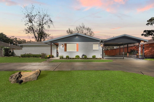 ranch-style home featuring a carport and a lawn