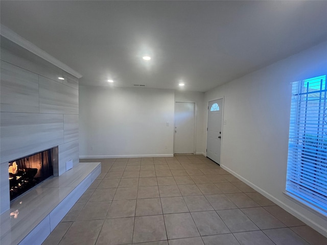 unfurnished living room featuring light tile patterned flooring and a fireplace