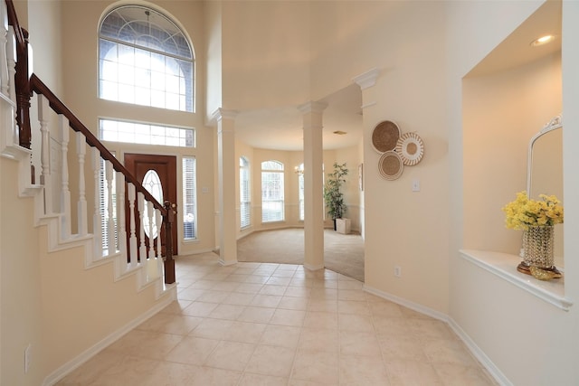 tiled foyer featuring a high ceiling and decorative columns