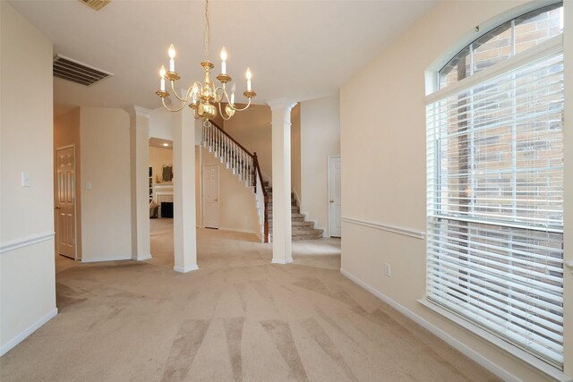 interior space featuring an inviting chandelier and decorative columns