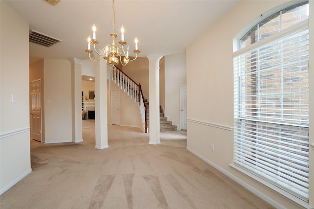 interior space with decorative columns and a notable chandelier