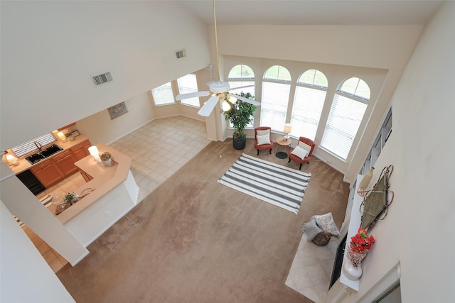 carpeted living room featuring ceiling fan, a wealth of natural light, and high vaulted ceiling