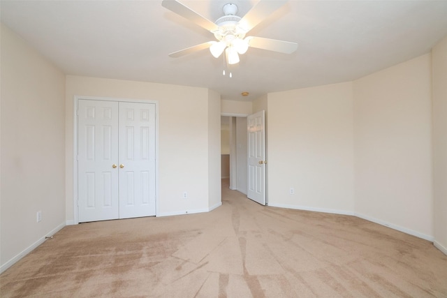 unfurnished bedroom with ceiling fan, a closet, and light colored carpet