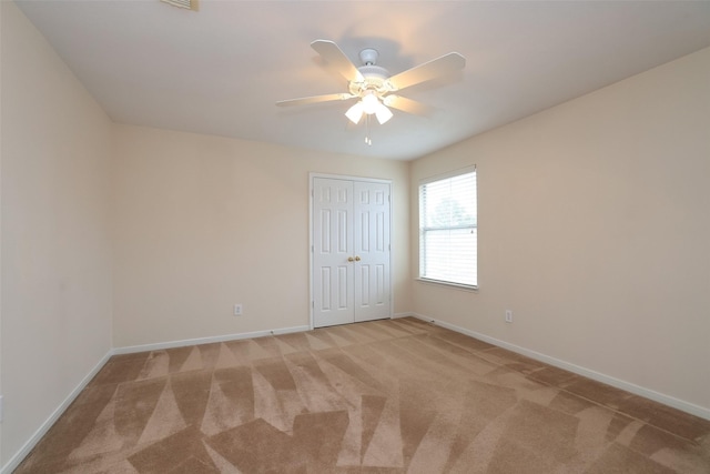 empty room with ceiling fan and light colored carpet