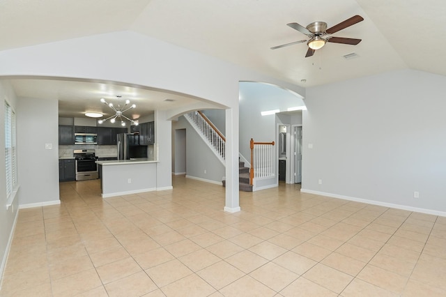 unfurnished living room with ceiling fan with notable chandelier, light tile patterned flooring, and lofted ceiling