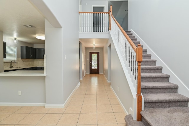 tiled foyer entrance featuring a high ceiling and sink