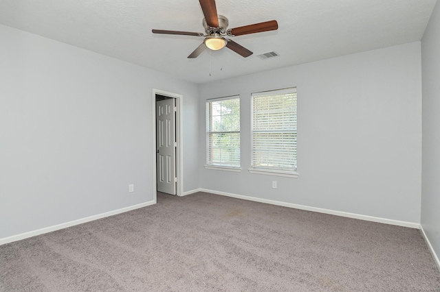 carpeted spare room with ceiling fan