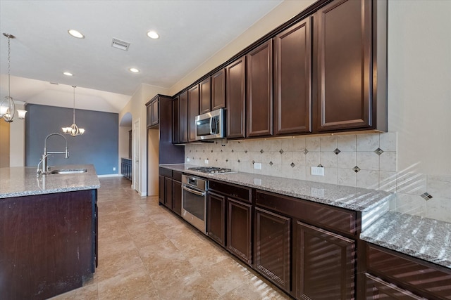 kitchen featuring hanging light fixtures, sink, decorative backsplash, appliances with stainless steel finishes, and a chandelier