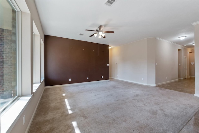 spare room featuring ceiling fan, crown molding, and light carpet