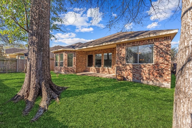 back of property with a yard and a patio area