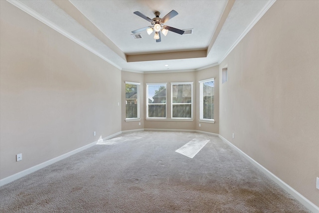 carpeted empty room featuring a tray ceiling, ceiling fan, and crown molding