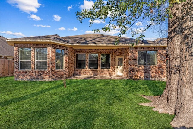 rear view of property with a yard and a patio