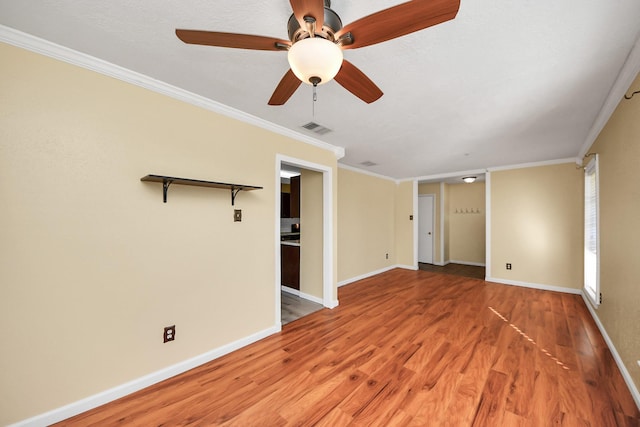 spare room featuring wood-type flooring and crown molding