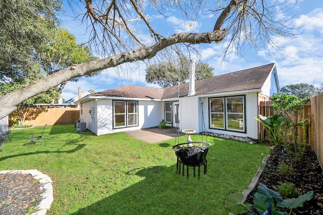 rear view of property featuring a lawn, cooling unit, and a patio