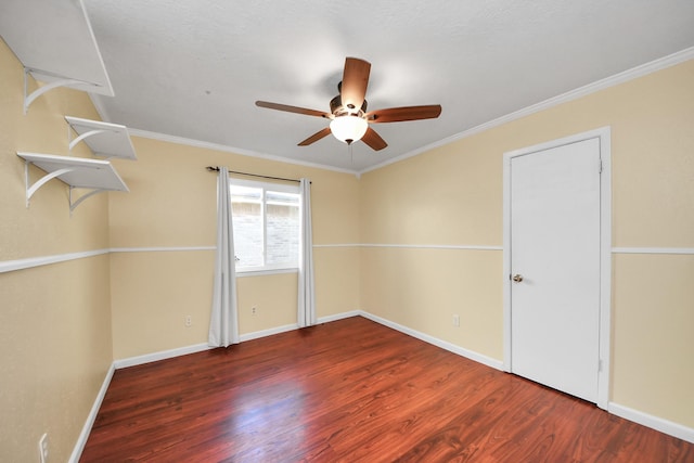 empty room with ceiling fan, dark hardwood / wood-style floors, and ornamental molding